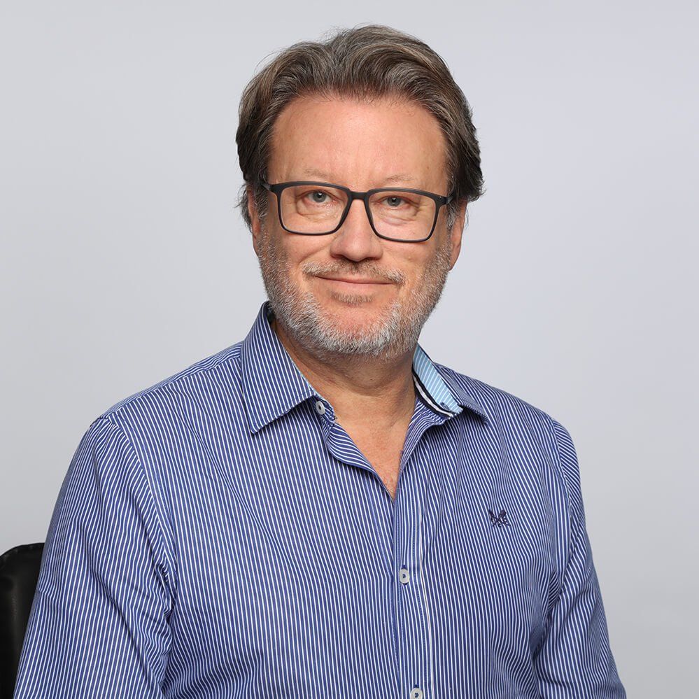 a man with glasses and a beard is wearing a blue striped shirt .