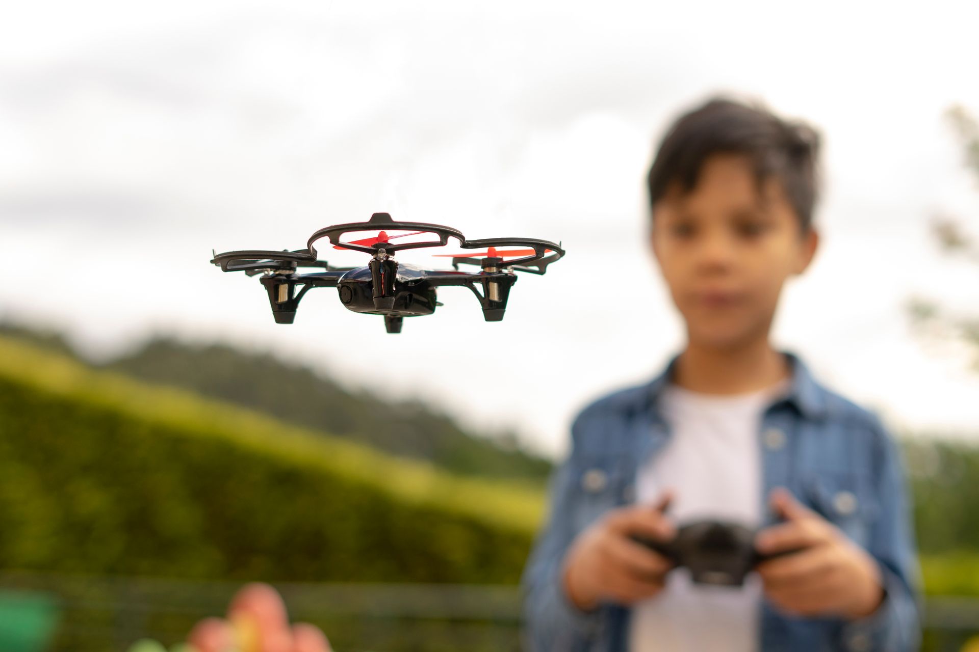 Close up of child flying drone in the park.