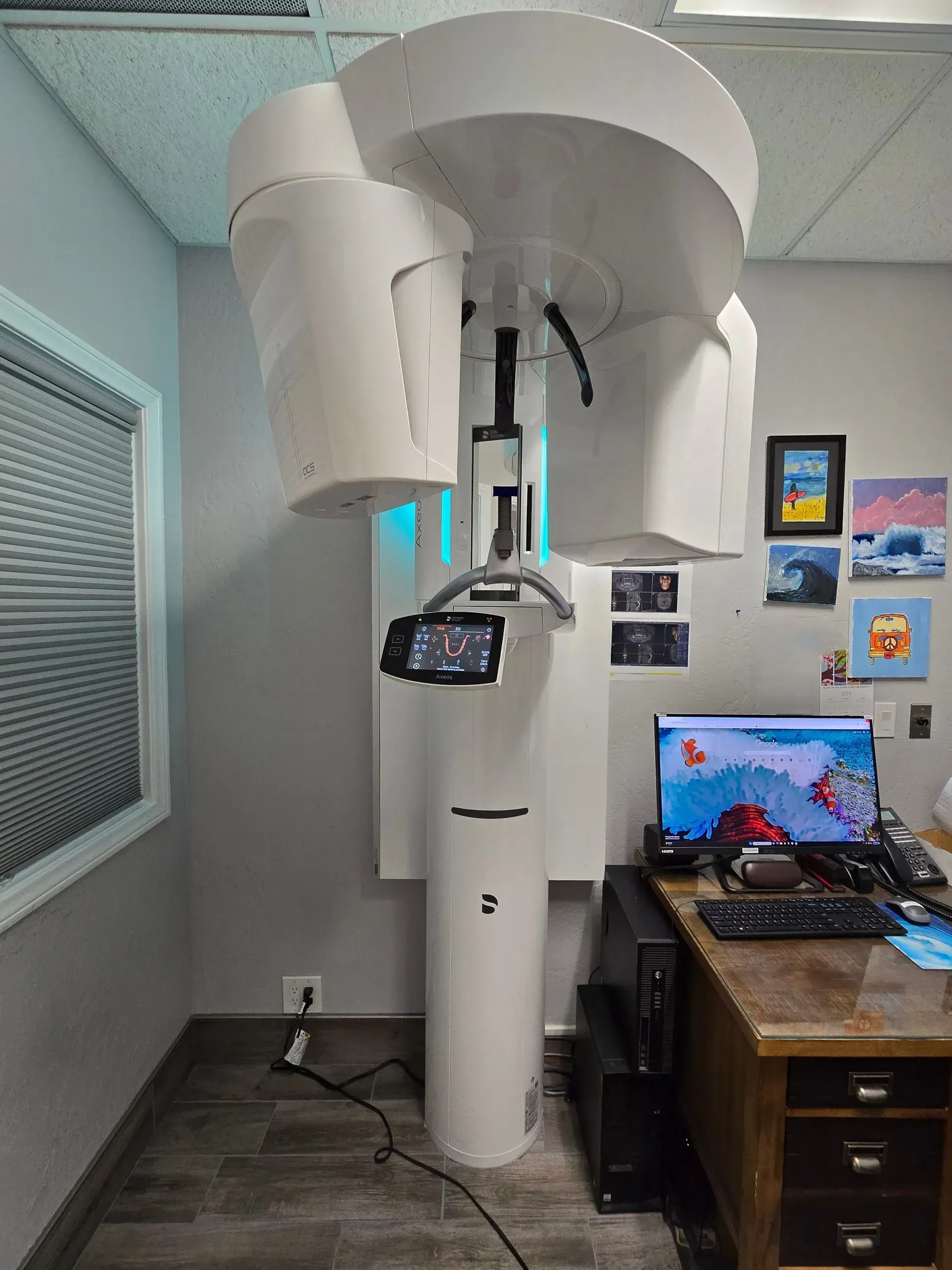 A large white machine is sitting in a room next to a desk.