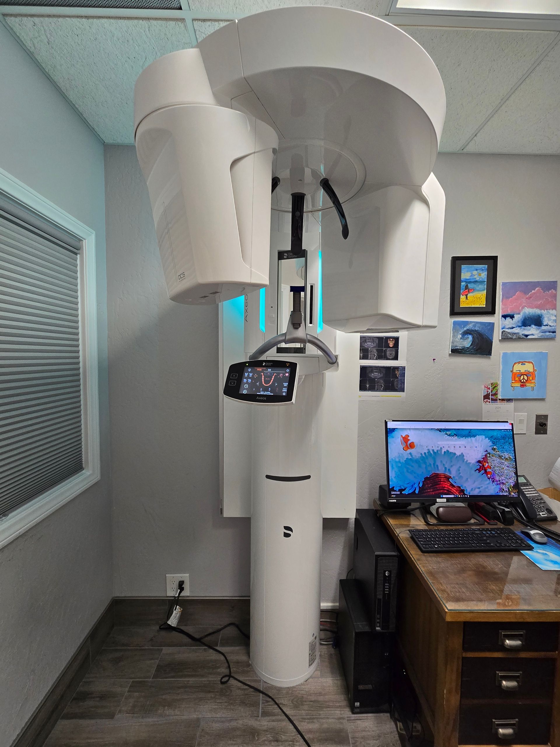 A large white machine is sitting in a room next to a desk.