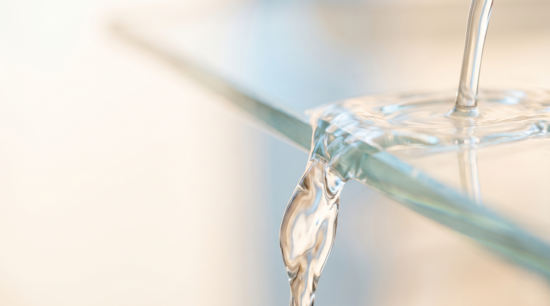 A person is pouring water into a glass from a faucet.