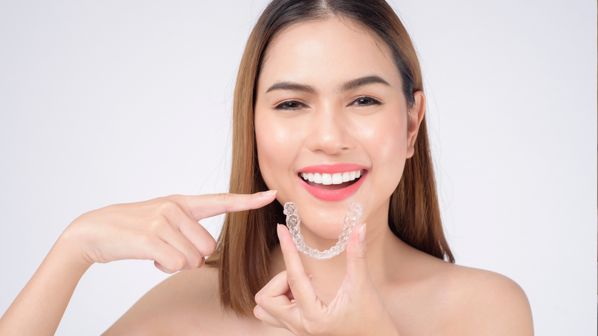 A person is holding a model of a tooth with a dental crown on it.