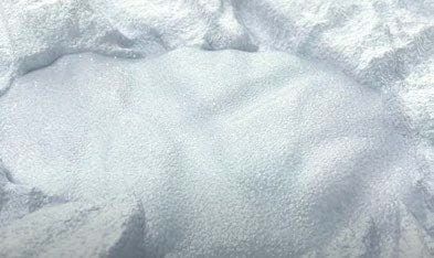 A pile of white sand is sitting on the ground.