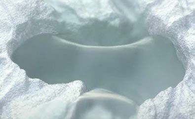 A close up of a hole in a pile of snow.