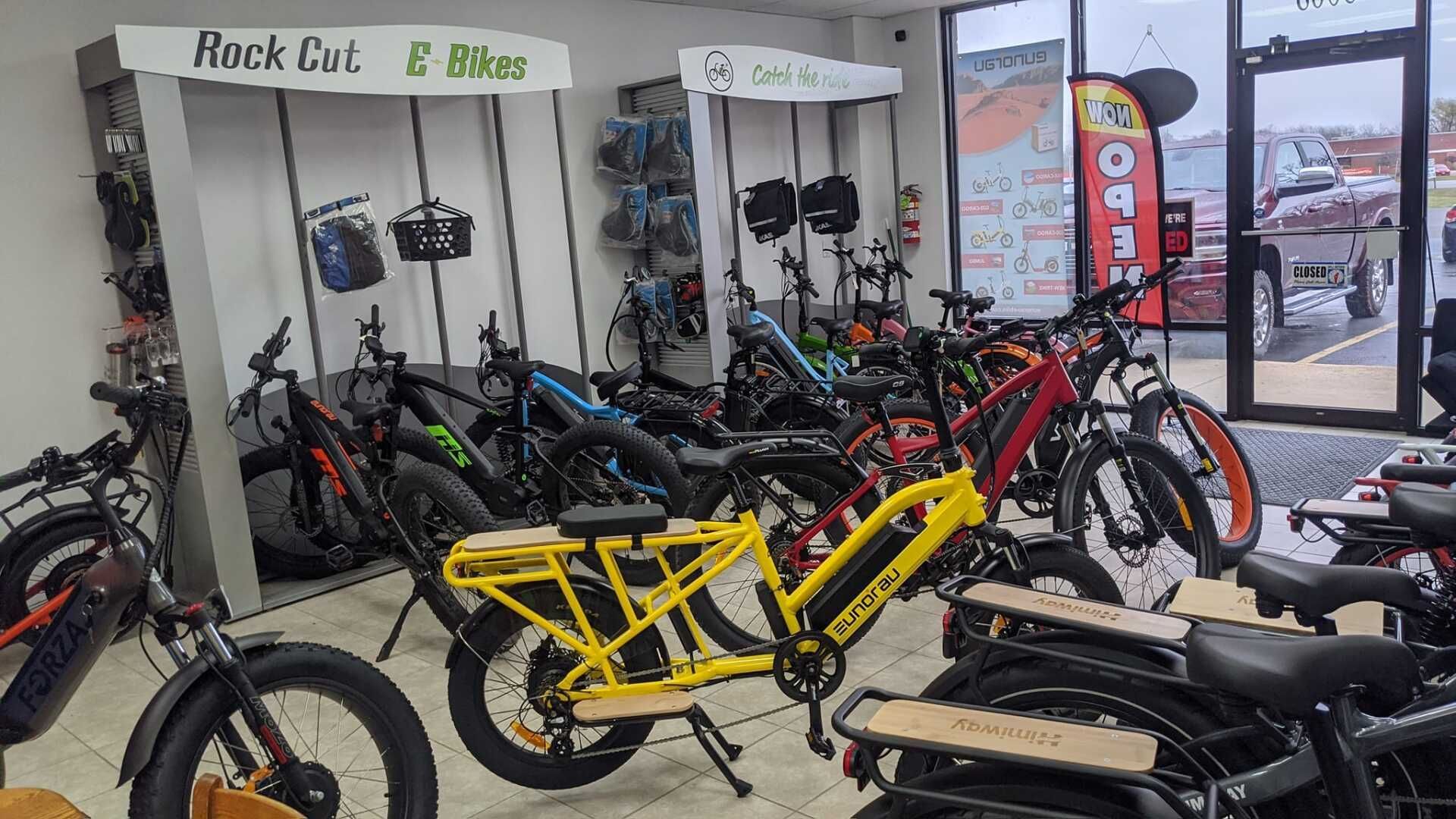 Indoor bike shop with several bicycles, including a bright yellow cargo bike in the foreground.