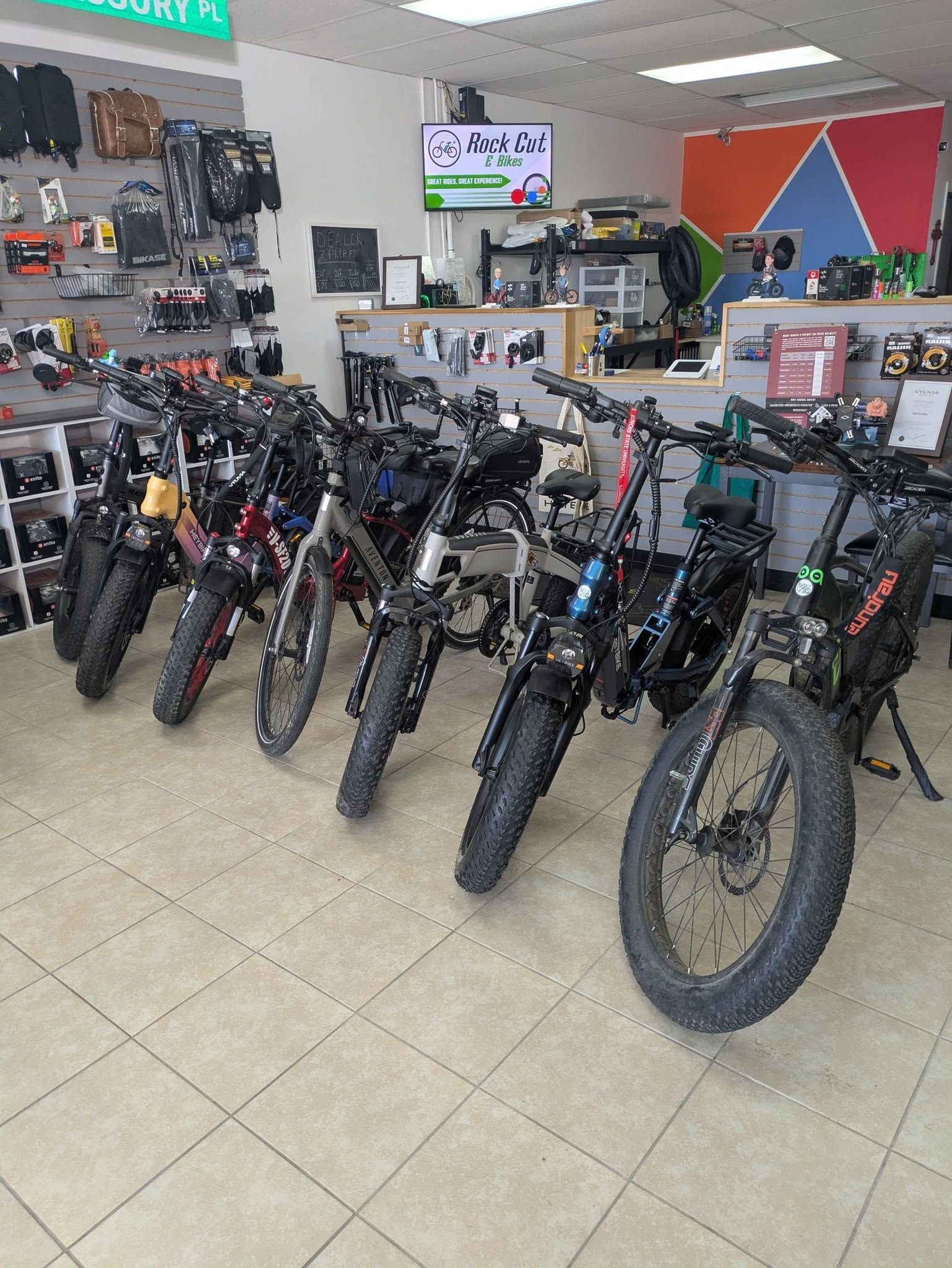 Row of mountain bikes displayed in a bicycle shop with accessories on the walls
