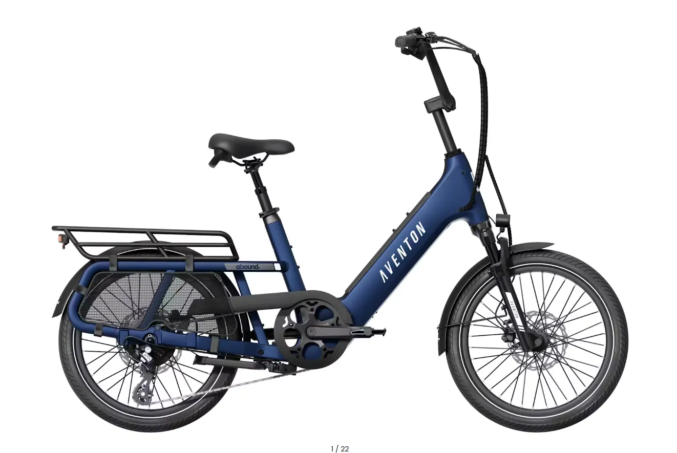 Blue folding electric bike with rear cargo rack and basket, shown in side view on a white background