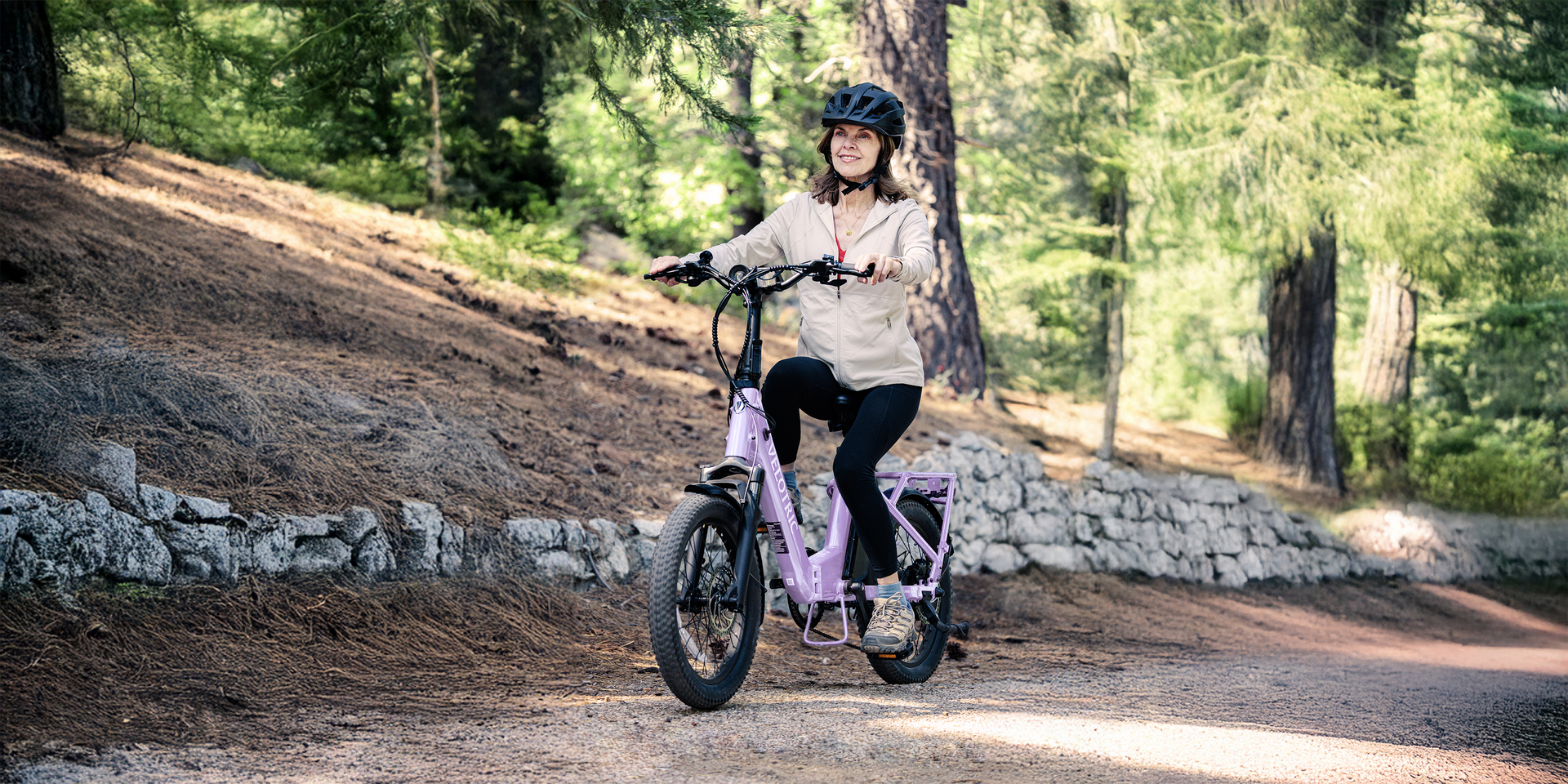 Person riding a purple electric scooter on a forest dirt path