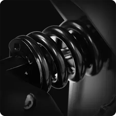 Close-up of a black metal coil spring with glossy highlights on a dark background