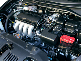 A close up of a car engine with a red battery