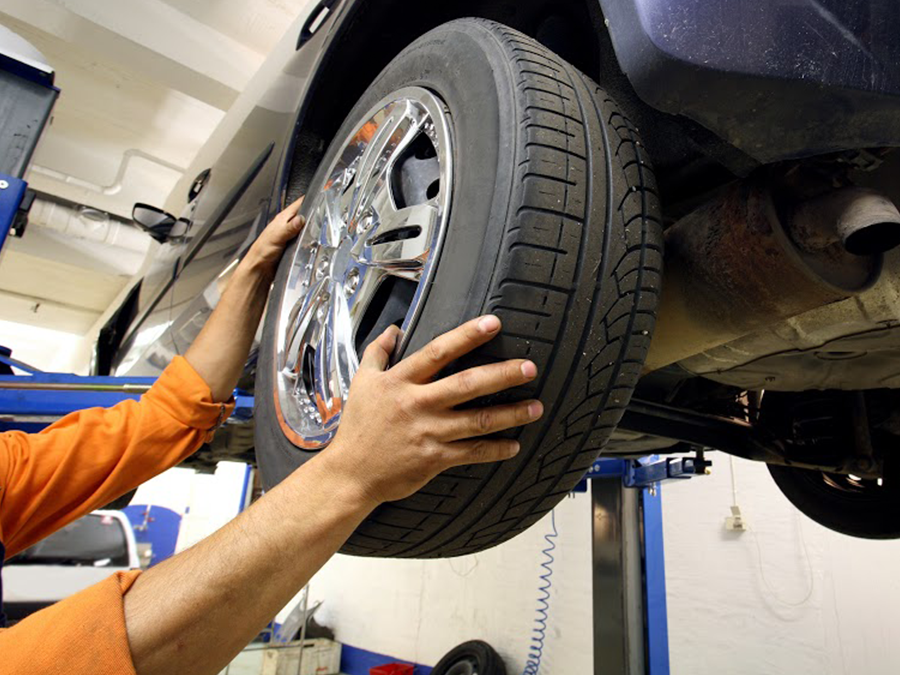 A man is changing a tire on a car
