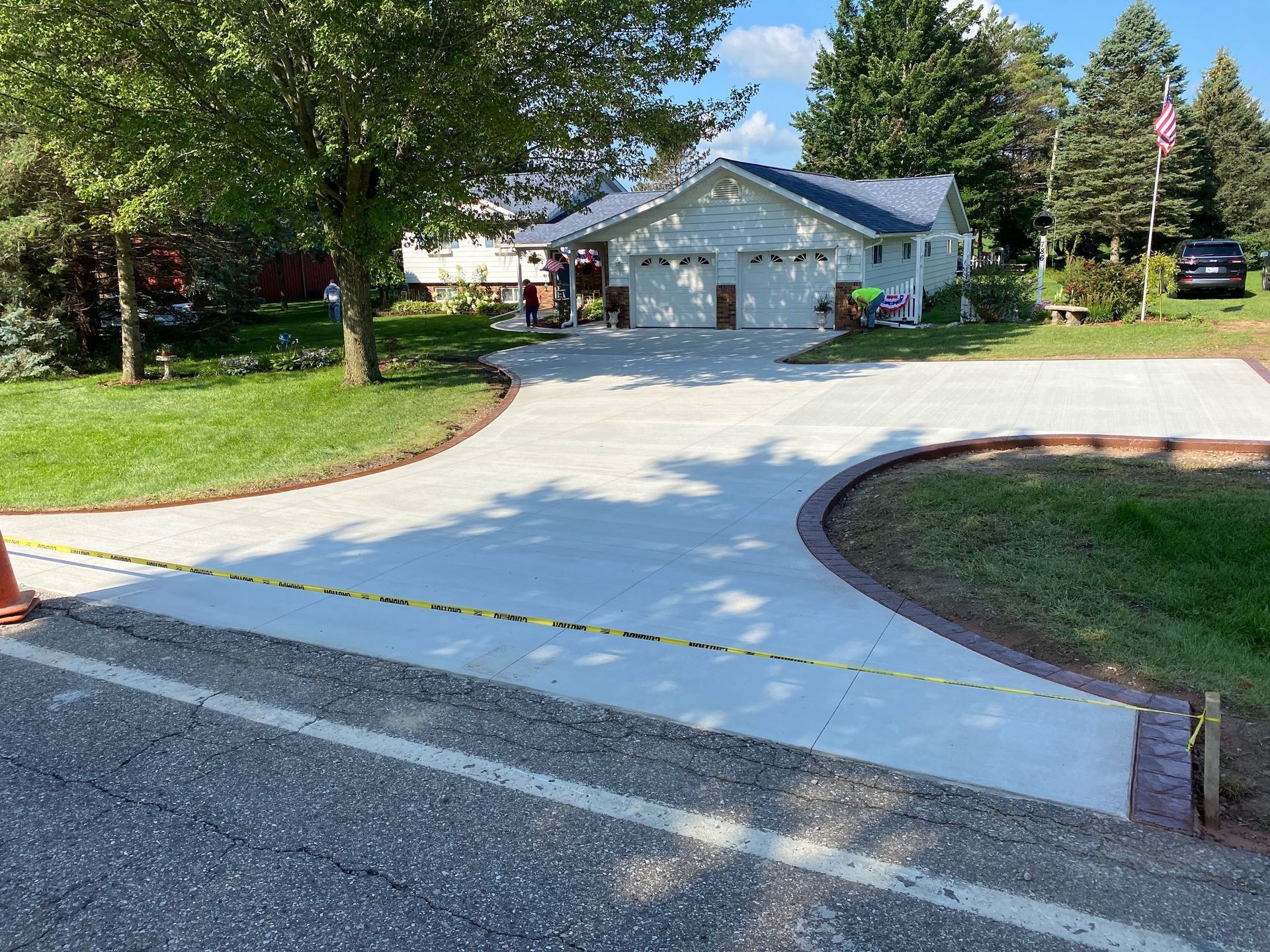 A concrete driveway is being built in front of a house.