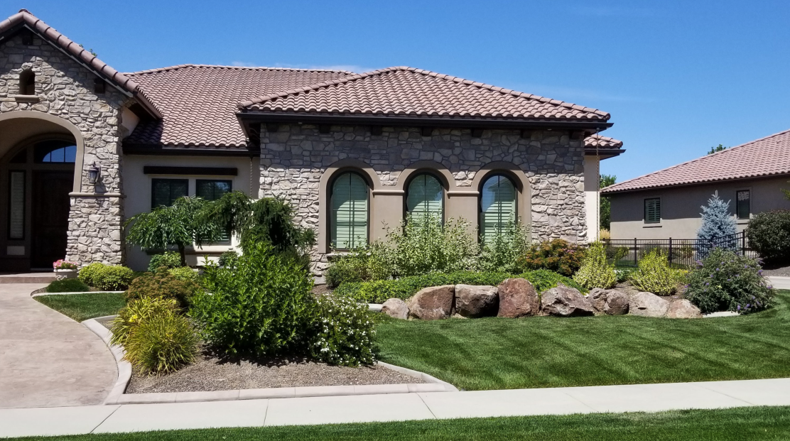 A large stone house with a tile roof and arched windows