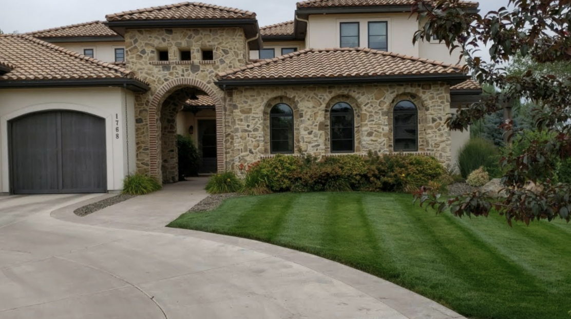 A large house with a lush green lawn in front of it.