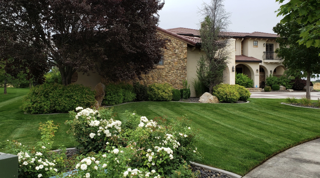 A large house with a lush green lawn in front of it.