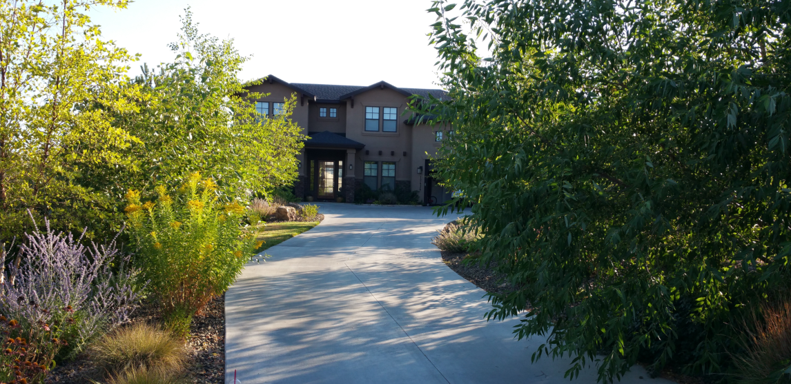 An aerial view of a large house surrounded by trees and bushes.