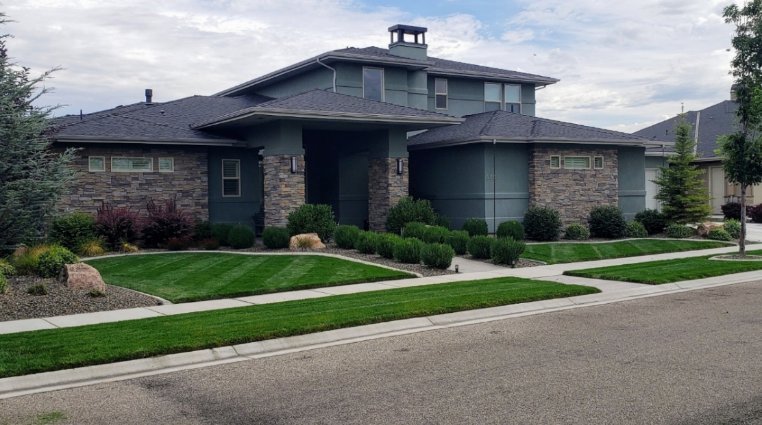 A large house with a lush green lawn in front of it.