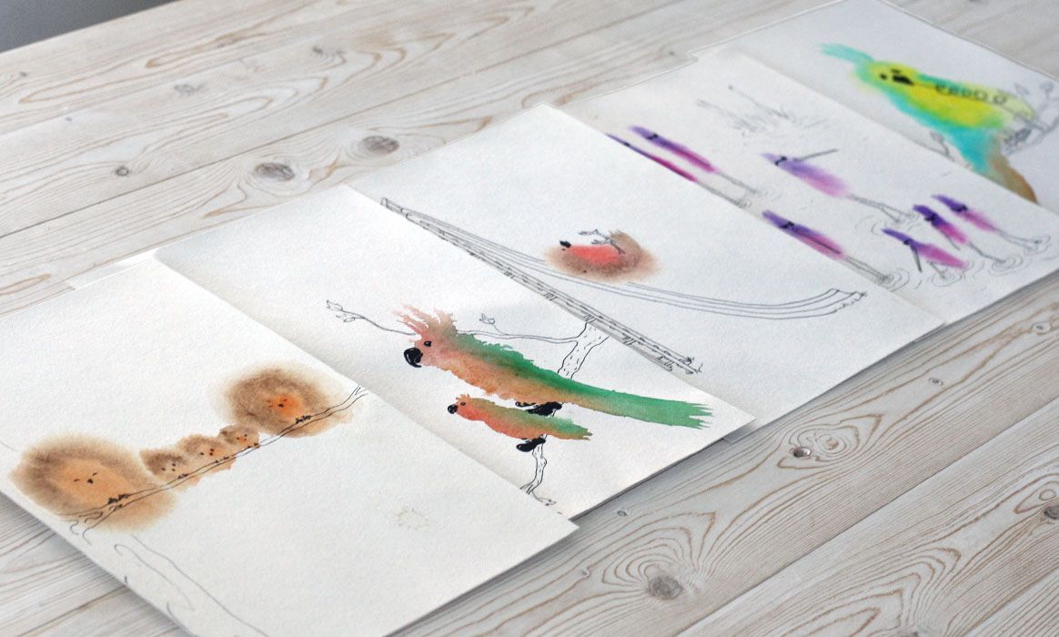 Een rij kaarten van grappige wezens op een houten tafel. Aquarel, pen tekening door Jasmijn Mulder, Atelierkinderen
