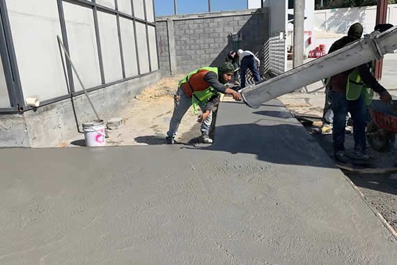 Un grupo de trabajadores de la construcción está trabajando en un camino de entrada de hormigón.