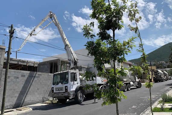 Un camión bomba de hormigón está estacionado al costado de la carretera.