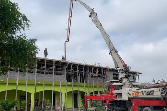 Una grúa está vertiendo hormigón en un edificio en construcción.