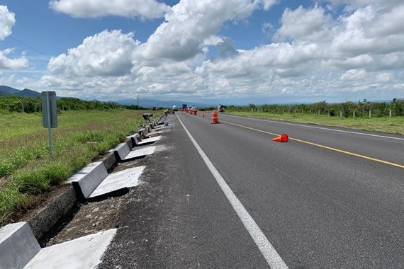 Una carretera con conos naranjas a los lados.