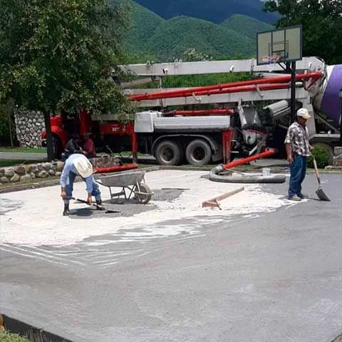 Un grupo de trabajadores de la construcción está trabajando en un camino de entrada de hormigón.
