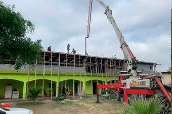 Se está utilizando una bomba de hormigón para verter hormigón en un edificio en construcción.