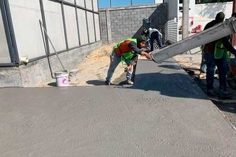 Un grupo de trabajadores de la construcción está trabajando en una acera.