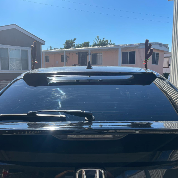 A honda car is parked in front of a house
