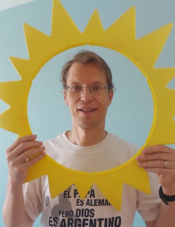 Martin schaut lachend durch, im Zentrum leere, Sonne.