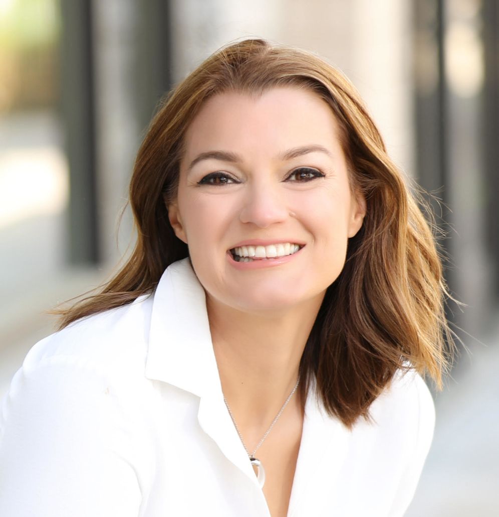 A woman in a white shirt is smiling for the camera