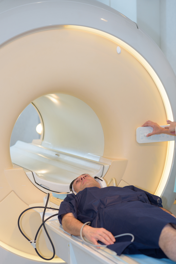 MalePatientCTScanScaled A man is laying in a mri machine.