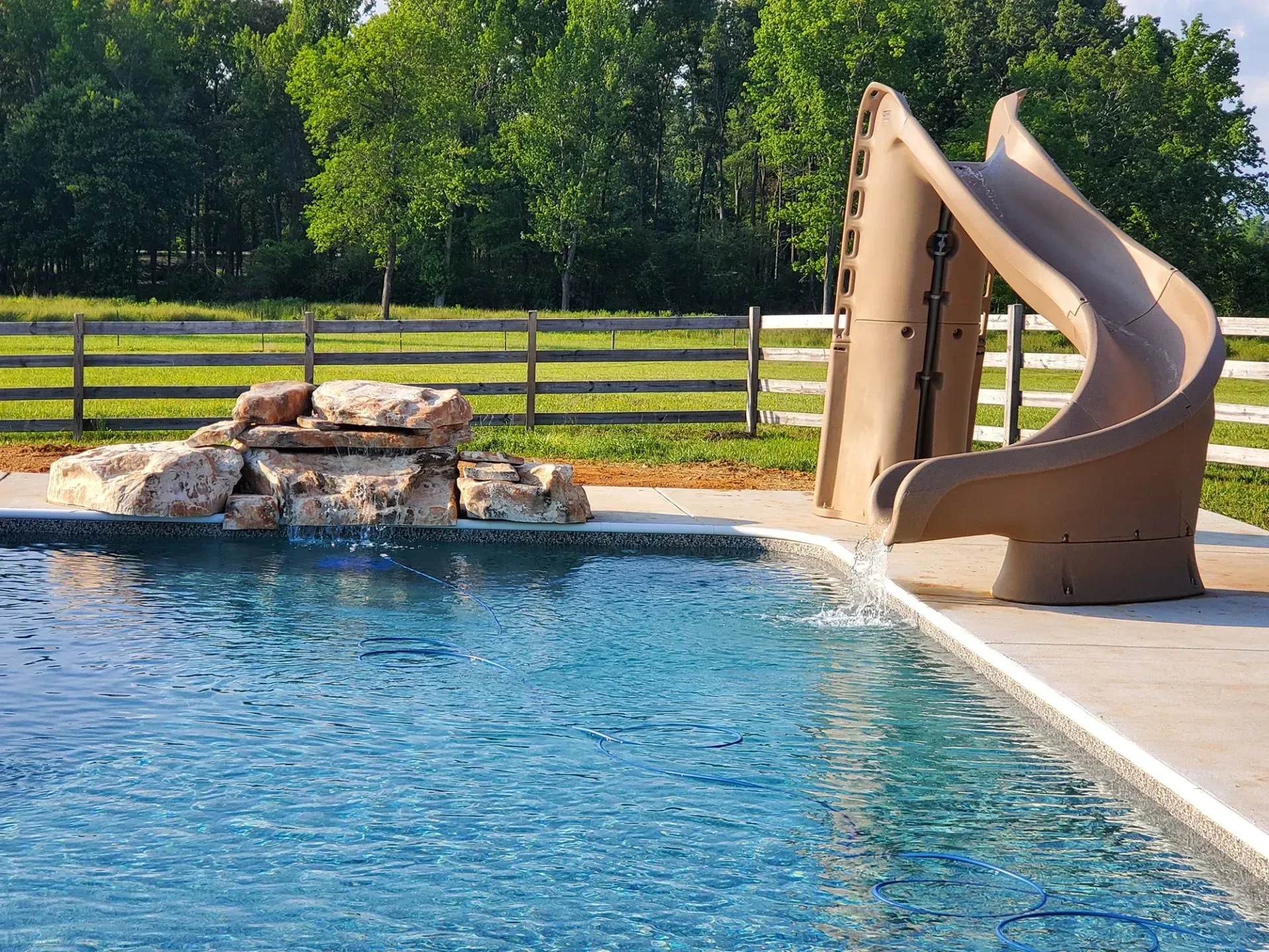A swimming pool with a water slide next to it