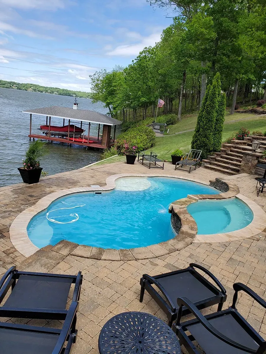 A large swimming pool with a boat dock in the background.
