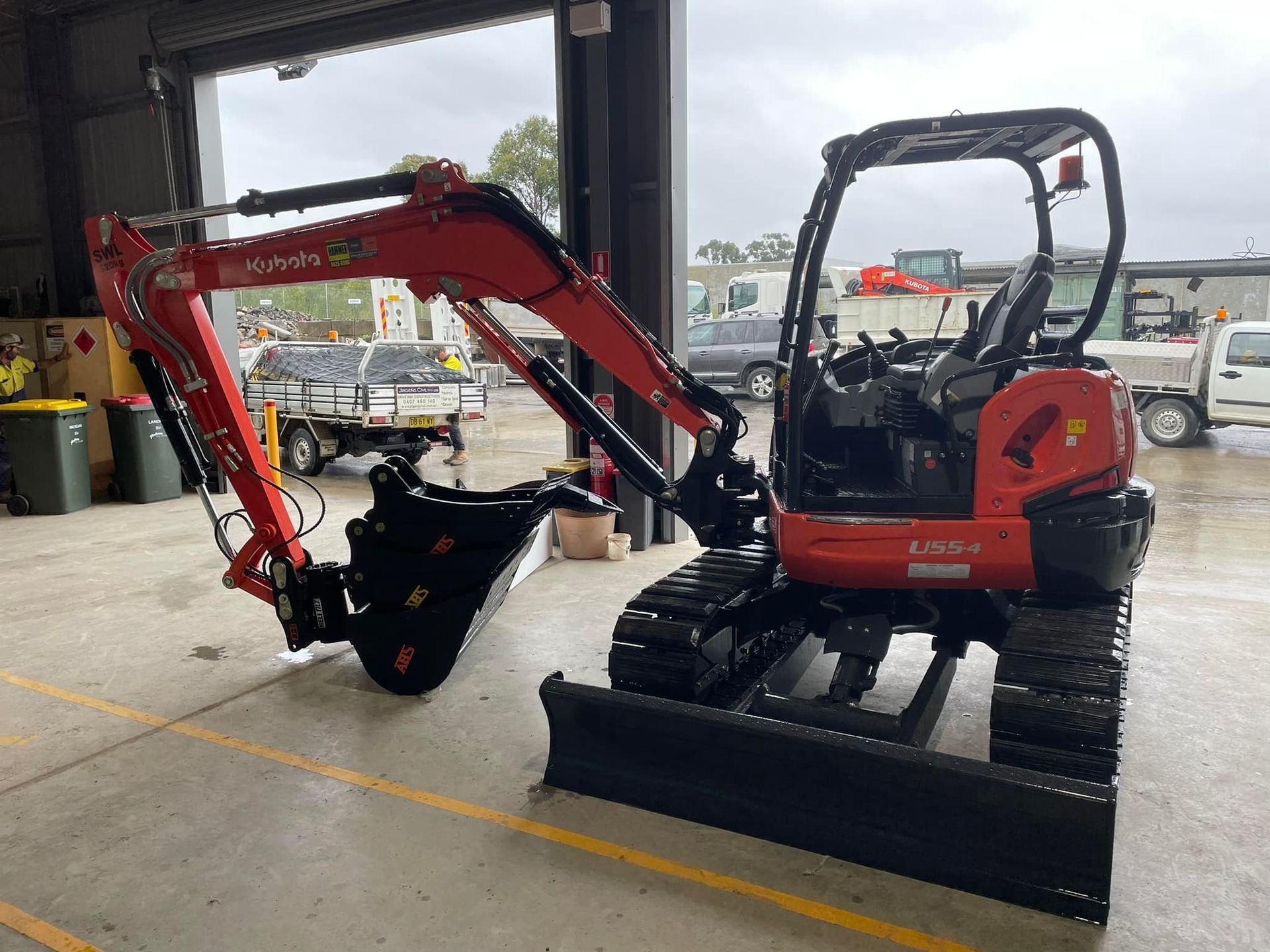 Red and Black Kubota Mini Excavator Parked Inside a Garage — ALI Civil Pty Ltd in South Nowra, NSW