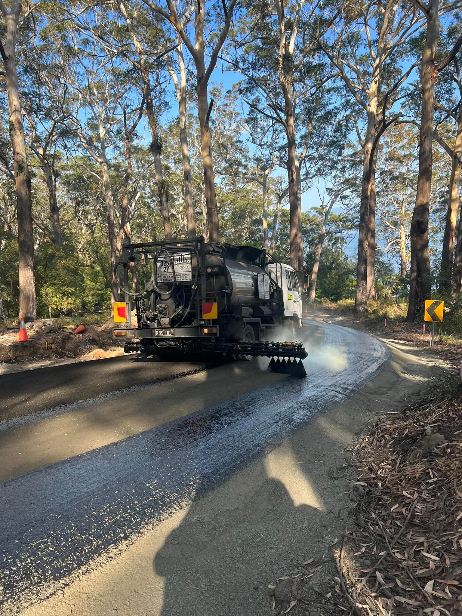 Road Paving Machine at Work, Laying Fresh Asphalt on a Forest Road — ALI Civil Pty Ltd in South Nowra, NSW
