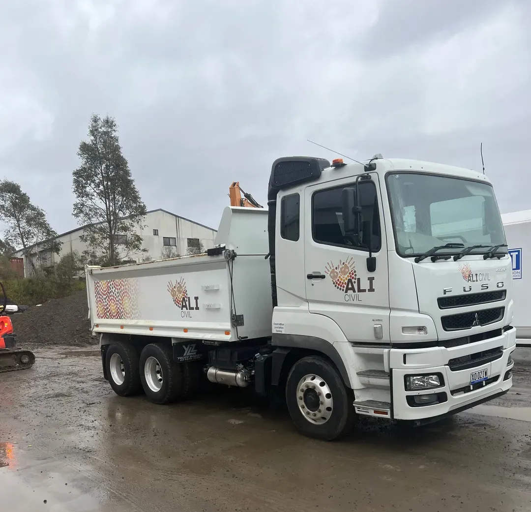 White Dump Truck Parked on Wet Pavement — ALI Civil Pty Ltd in South Nowra, NSW