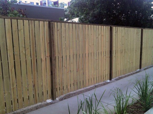 A Timber Fence Is Sitting Next To A Sidewalk — AAA Fencing & Supplies in Southport, QLD
