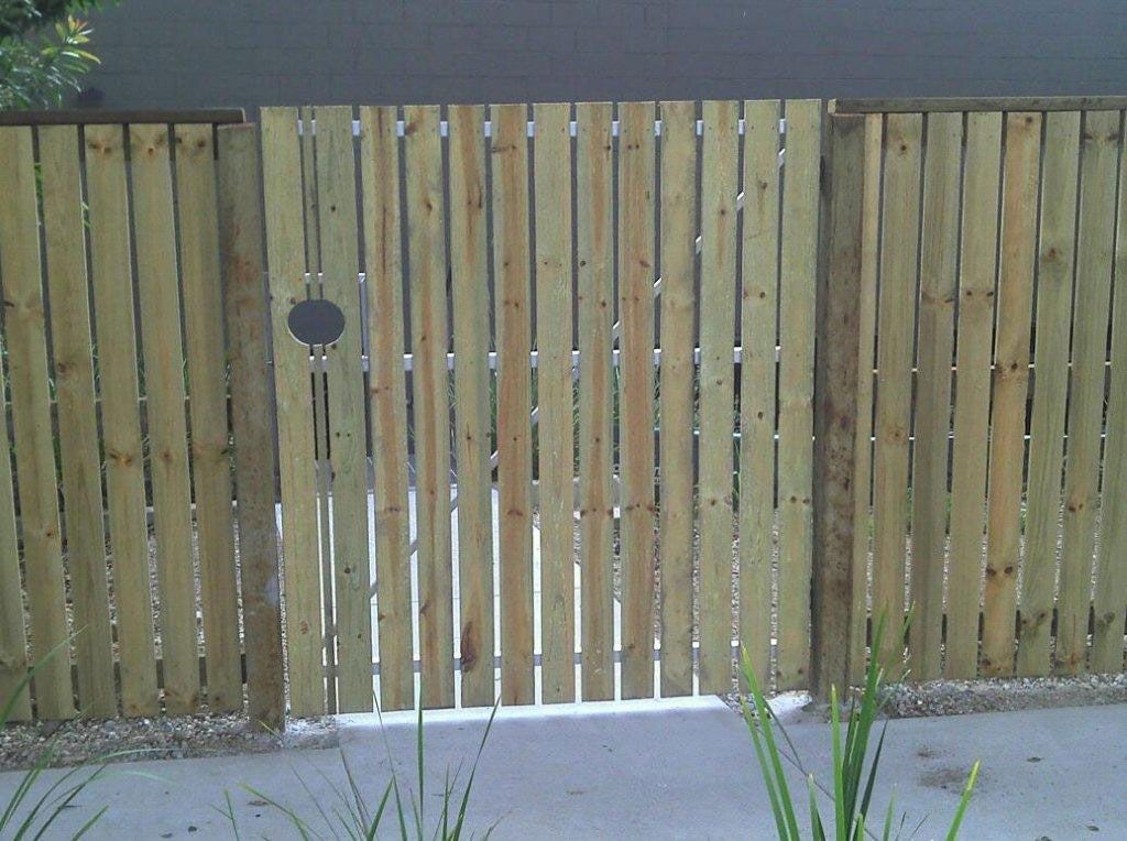 A Wooden Fence With A Small Hole In The Middle — AAA Fencing & Supplies in Southport, QLD