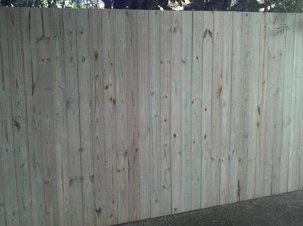 A Timber Fence Is Sitting On The Side Of A Road — AAA Fencing & Supplies in Southport, QLD