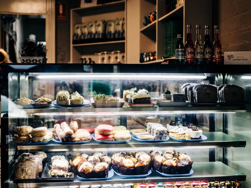Display case filled with pastries and cakes in a bakery.