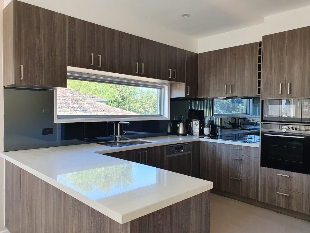 A kitchen with wooden cabinets and a white counter top.