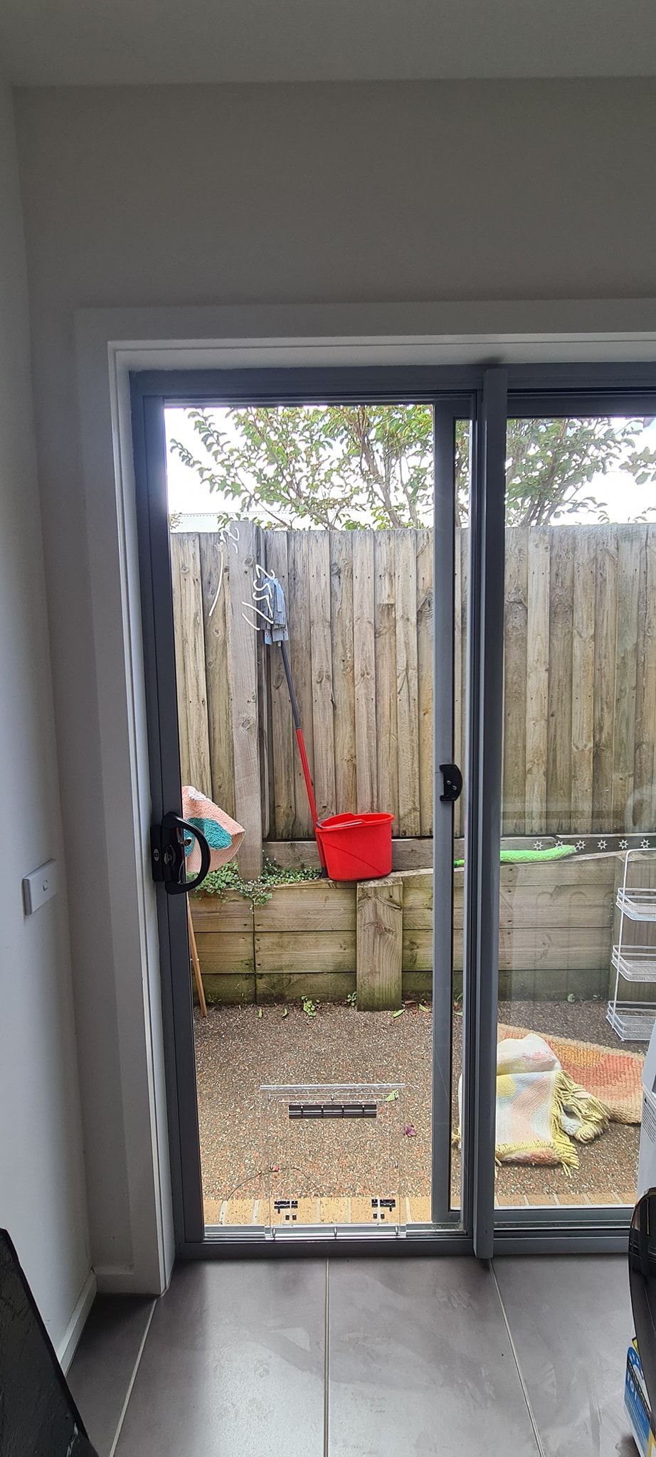 A room with a sliding glass door going to a backyard.