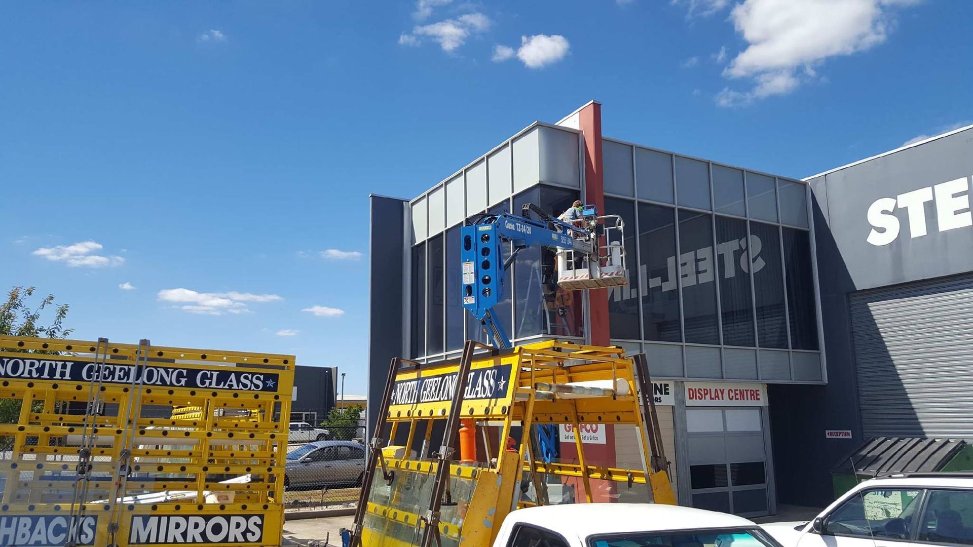 A yellow truck is parked in front of a building that says ste