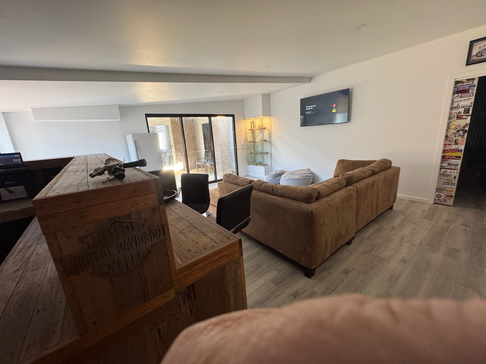 Living room with brown sofas, wooden furniture, and sliding glass doors to a patio