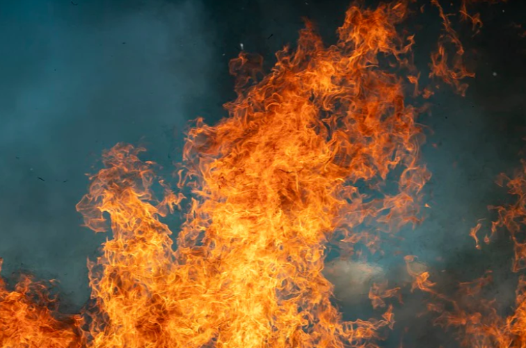 Large orange flames blaze against a dark smoky background.
