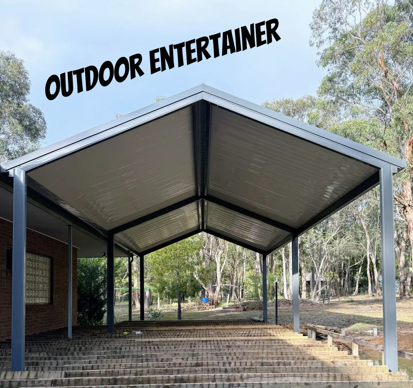 Blue metal shed in a grassy rural yard under a partly cloudy sky