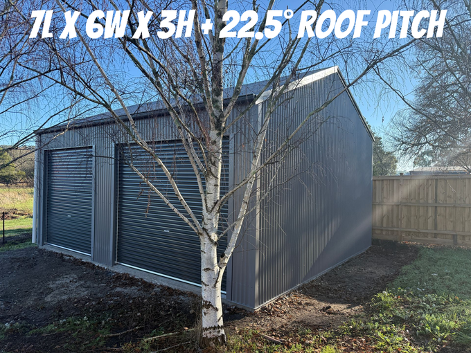 A large blue metal building with a garage door