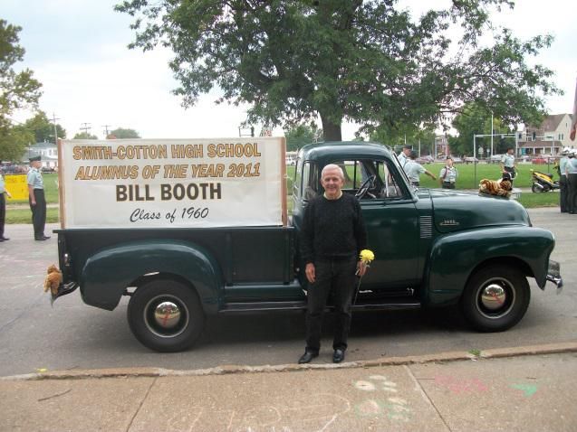 A man standing in front of a truck that says bill booth